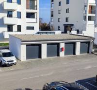 A view of Predmerského Street in Trenčín with an apartment building and parking.