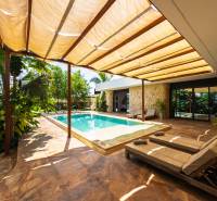 The garden of a family house on Paje Street in Unguja South Region with a swimming pool and sunbeds.