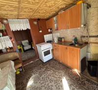 A kitchen with wooden decor, a sofa, and a carpet in the Gardens.