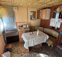 Interior of a cottage with an antique patterned table and wooden details in the Gardens.