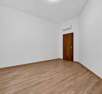 Empty space in a 4-room apartment with wood-patterned flooring and air conditioning.