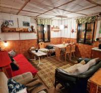 Rustic interior of a cottage with sofas, wooden decor, and decorations in a cozy atmosphere.