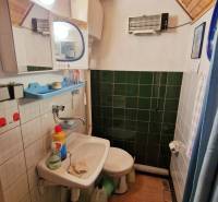 A bathroom in a cabin with a sink, toilet, and floor with a wood decor.
