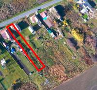 Aerial perspective of residential plots in the village of Radnovce with the main road.