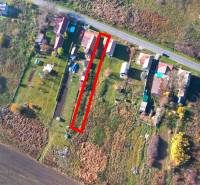 A top-down view of residential plots in Radnovce, surrounded by nature and a nearby road.