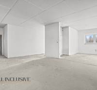 A bright room in a family house with a plasterboard ceiling and a large window.