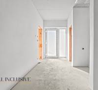 A bright hallway in a family house with two open doors and frosted glass.