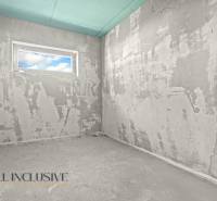 A rough construction of a room in a family house with a window and unfinished walls.