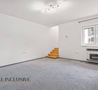 Living room with carpeted floor, window, and stairs in a family house.