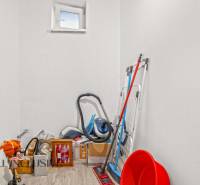 Storage space with cleaning supplies and a wooden decor floor in a family house.