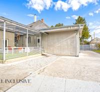 Family house in Veľké Kosihy: concrete terrace, shelter, garden, blue sky.