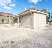 A family house in Veľké Kosihy with a terrace and a wide driveway, surrounded by greenery.