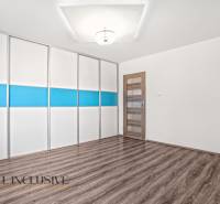 White room with a colorful built-in wardrobe and a wooden decor floor in a family house.