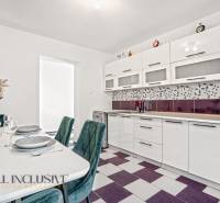 A kitchen in a family house with built-in appliances and geometric tiles.