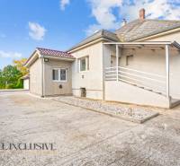 A family house in Veľké Kosihy with a sloped roof and a paved courtyard.