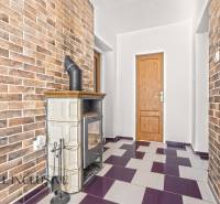 Interior of a family house with a tiled stove and brick walls.