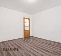 A white interior with doors and a wooden decor floor in a family house.