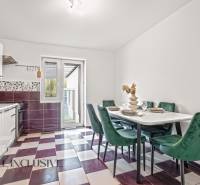 A kitchen with a dining table, colorful floor, and an exit to the terrace in a family house.