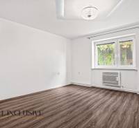 A room in a family house with a wooden decor floor and white walls.