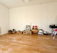 A room in a family house with a wooden decor floor and various objects by the wall.