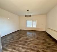 Living room with wood-patterned flooring and a radiator in a family house.