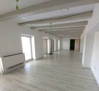 White office with wood-patterned flooring, decorative beams, and light-colored walls.