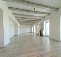 Bright offices with wood-patterned flooring and large windows.