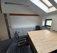 Interior of an office with a conference table and chairs, floor with wooden decor.