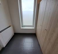 Office with tiles, storage space, and a large window, without furniture.