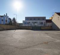 Asphalt area in front of buildings in Nové Zámky, ideal for residential plots.