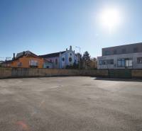 A plot in Nové Zámky suitable for living, surrounded by buildings and sunny weather.