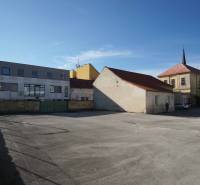 A parking lot surrounded by buildings in Nové Zámky, ideal for residential land.