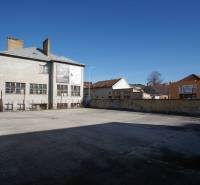 Exterior of buildings and open area in the town of Nové Zámky, suitable for residential land.