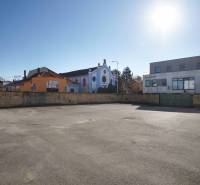 Photograph of a residential plot in Nové Zámky. The shot shows buildings in the background.