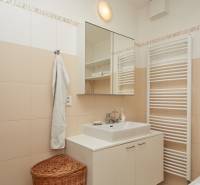 Bathroom in a 2-room apartment with white furniture, a mirror, and a towel.
