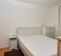 Bedroom in a 2-room apartment with a double bed, nightstand, and dresser.