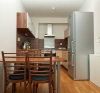 A kitchen in a 2-room apartment with a wooden decor floor and wooden furniture.