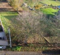 A residential plot in Dolná Krupá on M.H. Chvoteková surrounded by greenery and trees.
