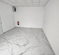 White walls, marble tiles, commercial spaces, fire extinguisher.