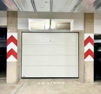 A closed garage on Karpatská Street in Poprad with white doors and a concrete floor.