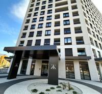 A high-rise building on Karpatská Street in Poprad with a modern entrance and curved walkways.