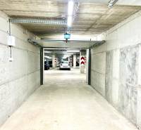 Concrete garages with open doors and parked cars.