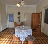 Dining room in a family house with a round table, patterned floor, and wooden furniture.