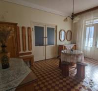 Interior of a family house with colorful tiles, a flower vase, and curtains.