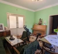 Living room in a family house with furniture, exercise equipment, and green walls.