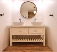 A bathroom in a 3-room apartment with a double sink and a wooden decor floor.