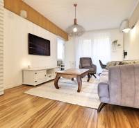 Living room with a sofa and an armchair in a 3-room apartment with a wooden decor floor.