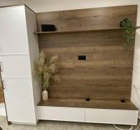 In the 1-room apartment, there is a wardrobe wall with a wooden decor and flowers in a vase.