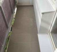 A narrow balcony with ceramic tiles in a studio apartment.