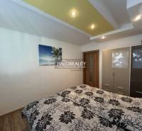 A bedroom in a 2-room apartment with a bed, a wardrobe, and a decorative ceiling.